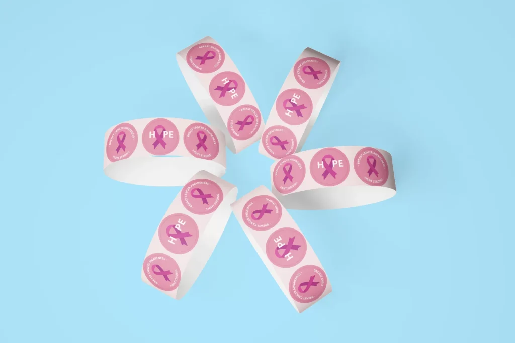 Wristbands arranged to form a flower with a pattern of the Breast Cancer Awareness logo illustrated on them.