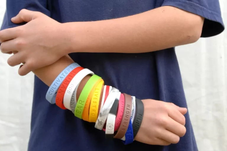 A person wearing a collection of silicone wristbands, highlighting their potential for reuse and sustainability.