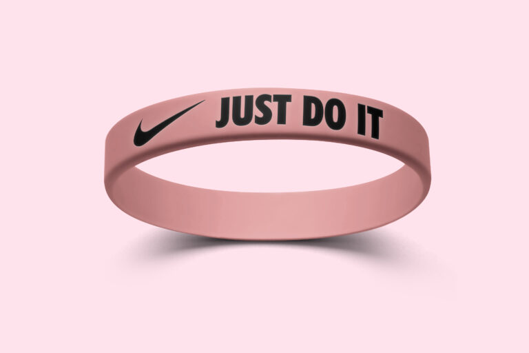 A pink silicone wristband featuring the Nike logo and the phrase "Just Do It."